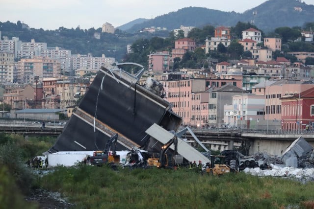 A piece of the A10 freeway, part of the Morandi Bridge in Genoa that collapsed on August 14, 2018, lies on its side on the ground. Photo: Valery Hache / AFP.